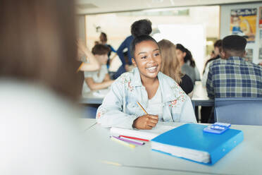 Glückliche, zuversichtliche Schülerin, die im Klassenzimmer lernt - CAIF25230