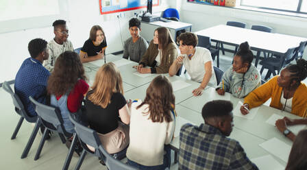 High school students talking at table in debate class - CAIF25257