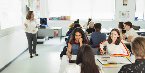 Highschool-Schülerinnen unterhalten sich während des Unterrichts am Tisch im Klassenzimmer - CAIF25264