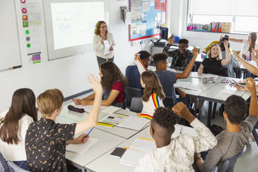 Gymnasiasten mit erhobenen Händen während des Unterrichts im Klassenzimmer - CAIF25277