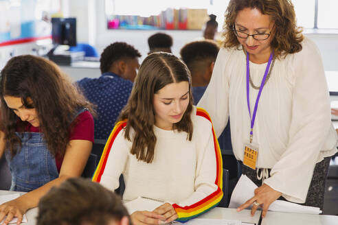 Gymnasiallehrerin hilft Schülerin bei den Hausaufgaben im Klassenzimmer - CAIF25282
