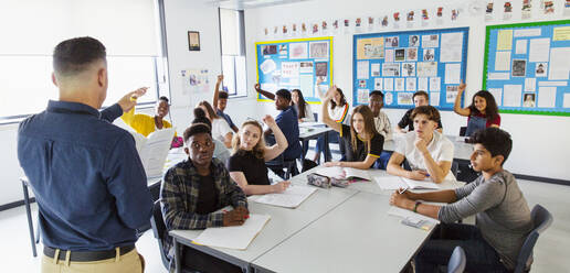 Gymnasiallehrer fordert Schüler mit erhobenen Händen im Klassenzimmer auf - CAIF25292