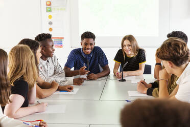 Lächelnde High-School-Schüler im Gespräch im Debattierkurs - CAIF25294