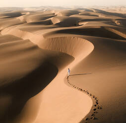 Aerial view of man walking at sand dunes at Sandwich Harbour, Namibia. - AAEF07756