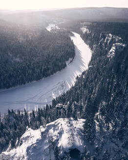 Luftaufnahme des Gipfels über dem zugefrorenen Fluss Usva im Winterwald im mittleren Ural, Region Perm, Russland. - AAEF07767