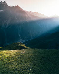 Aerial view of breathtaking moment of sunset in the mountain with a man standing on the edge infront of sunlights, Kabardino-Balkaria, Russia. - AAEF07770