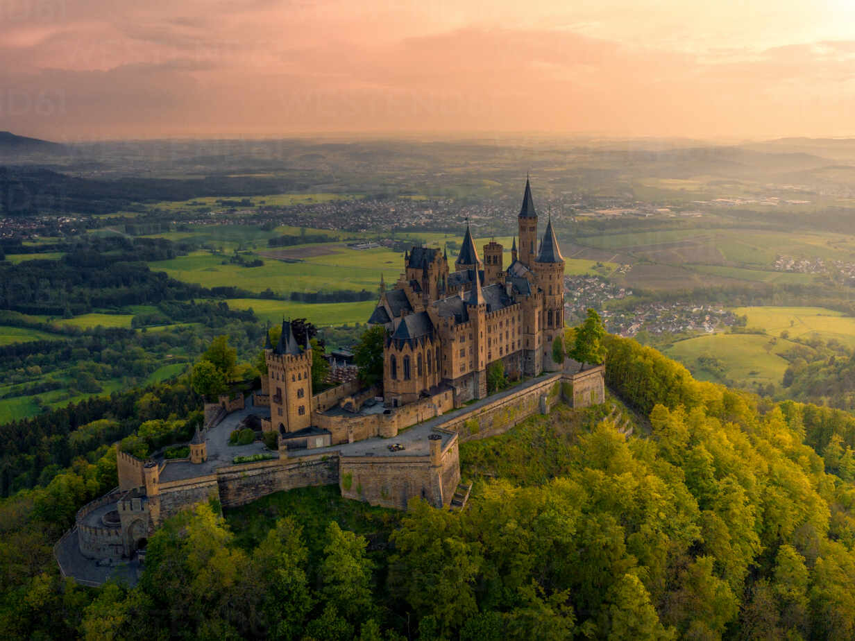 Luftaufnahme von Hechingen, Baden-Württemberg, Deutschland mit dem  Hohenzollernberg, der Burg Hohenzollern und Bäumen bei Sonnenuntergang,  lizenzfreies Stockfoto
