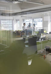 Business people working in open plan office - CAIF25335