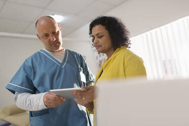 Ärzte mit digitalem Tablet bei einer Besprechung in einer Arztpraxis - CAIF25388