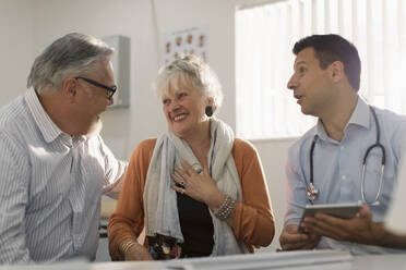 Arztgespräch mit einem glücklichen älteren Paar in einer Arztpraxis - CAIF25390