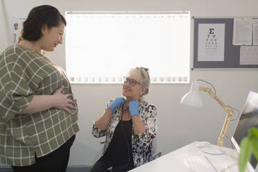 Ärztin untersucht schwangere Frau in Arztpraxis - CAIF25422