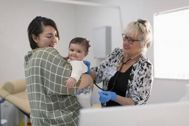Eine Kinderärztin untersucht ein kleines Mädchen im Untersuchungsraum - CAIF25424