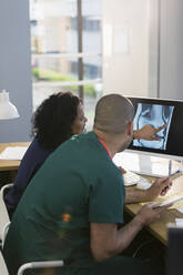 Nurses discussing digital x-ray at computer in clinic - CAIF25470