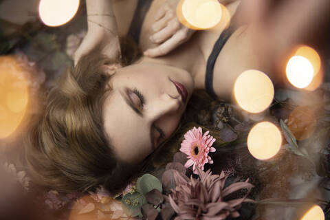 Beautiful woman lying on flowers, close up stock photo