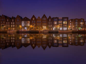 Gebäude spiegeln auf See in der Stadt in der Abenddämmerung - EYF02064