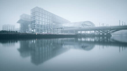 Berlin Hauptbahnhof With Reflection On River Against Sky In Foggy Weather - EYF02097
