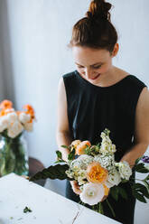High Angle View Of Frau Arranging Blumen in Vase am Tisch - EYF02152