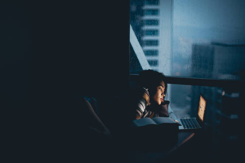 Woman Using Laptop While Lying At Home - EYF02215