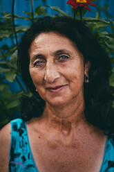 Porträt einer lächelnden älteren Frau mit schwarzem Haar - EYF02225
