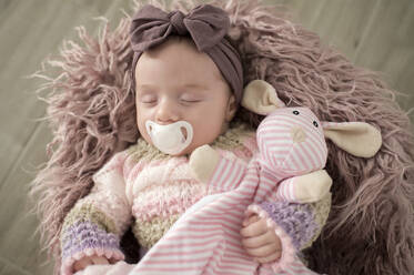 Porträt eines schlafenden kleinen Mädchens mit Haarband, Stofftier und Schnuller - KIJF02955