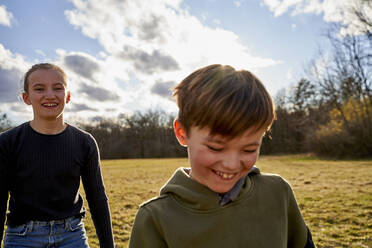 Happy brother and sister on a meadow - AUF00274