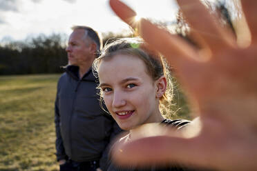 Porträt eines lächelnden Mädchens mit ihrem Vater auf einer Wiese - AUF00283