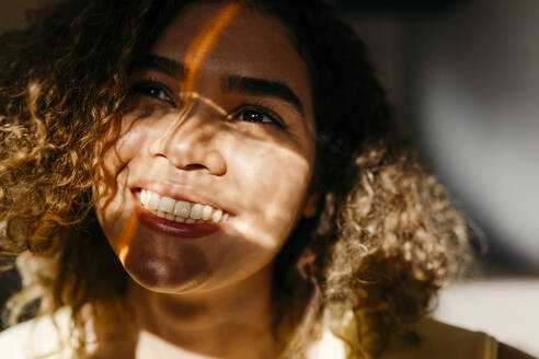 Porträt einer glücklichen jungen Frau im Sonnenlicht - TCEF00419
