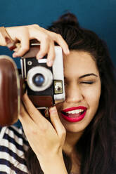 Porträt einer jungen Frau mit roten Lippen, die den Betrachter mit der Kamera fotografiert - LSF00092