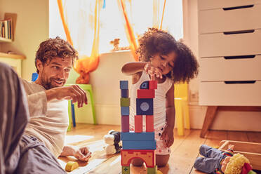 Father and daughter playing with wood blocks - CAIF25476