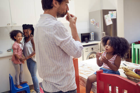 Junge Familie isst Obst in der Küche - CAIF25477