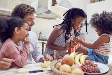 Young family eating fruit on table - CAIF25485