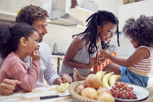 Junge Familie isst Obst auf dem Tisch - CAIF25485