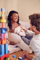 Glückliches schwangeres Paar im Gespräch - CAIF25501