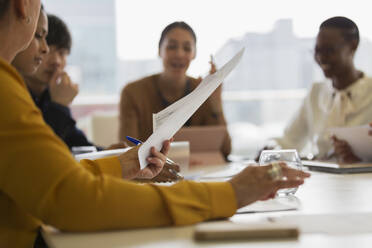 Business people discussing paperwork in conference room meeting - CAIF25536