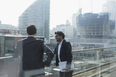 Geschäftsleute im Gespräch auf einem sonnigen, städtischen Balkon, Shoreditch, London - CAIF25608