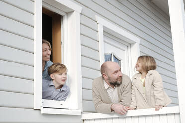 Happy family on porch of their house - VYF00123