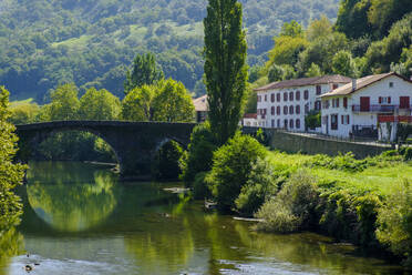 Frankreich, Pyrenees-Atlantiques, Bidarray, Bogenbrücke über den Fluss Nive mit Dorfhäusern im Hintergrund - LBF02986