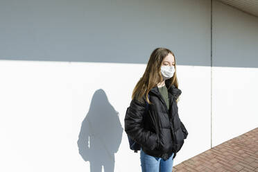 Girl with mask standing in front of a wall - OJF00368