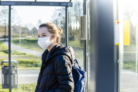 Portrait of a girl with mask waiting at bus stop stock photo