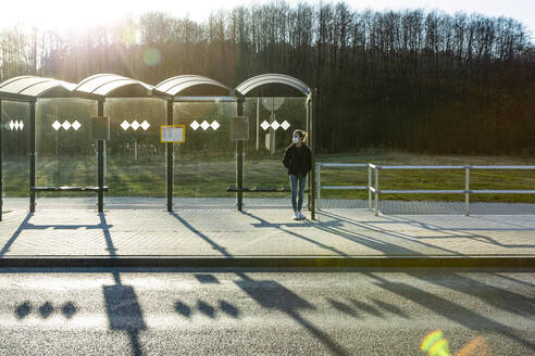 Portrait of a girl with mask waiting at bus stop - OJF00384