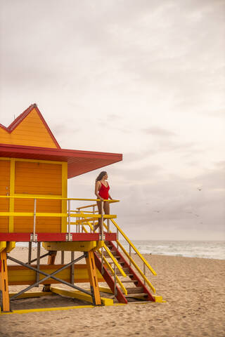 Frau in roter Badehose auf Rettungsschwimmerhütte am Miami Beach, Miami, Florida, USA, lizenzfreies Stockfoto