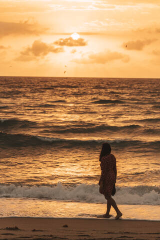 Frau an der Strandpromenade bei Sonnenaufgang, Miami, Florida, USA, lizenzfreies Stockfoto