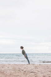 Young woman standing on the beach, tilted - FVSF00017