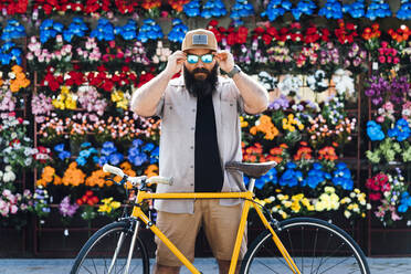 Porträt eines bärtigen Mannes mit Fixie-Fahrrad und verspiegelter Sonnenbrille - JCMF00541