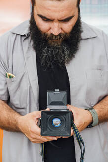 Bärtiger Mann beim Fotografieren mit Kamera - JCMF00563