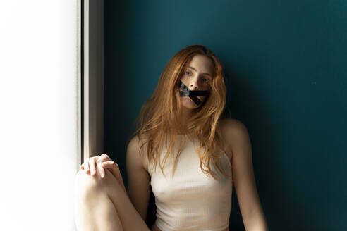 Porträt einer jungen Frau mit zugeklebtem Mund - AFVF05952