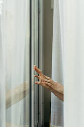 Hand of a woman touching windowpane - AFVF05957