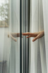 Hand einer Frau berührt Fensterscheibe - AFVF05958