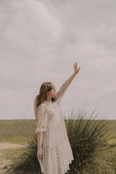 Frau in Vintage-Kleid allein auf einem abgelegenen Feld auf dem Lande - ERRF03062