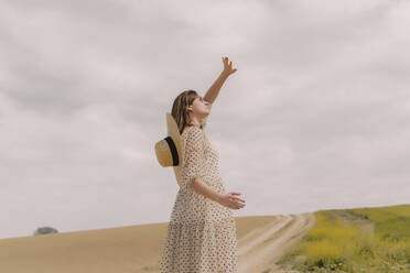 Frau in Vintage-Kleid allein auf einem abgelegenen Feld auf dem Lande - ERRF03071
